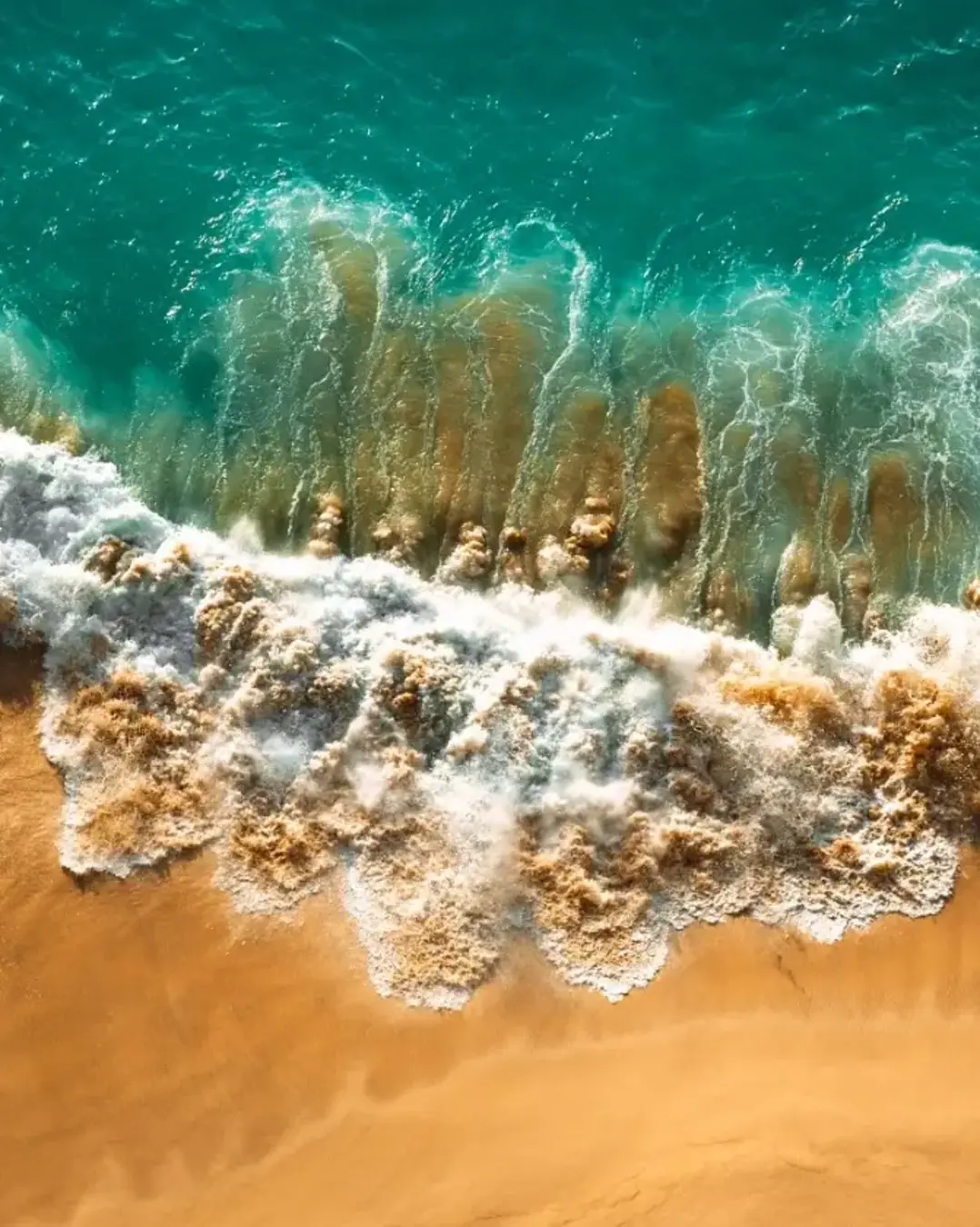 Aerial view of turquoise ocean waves in Kelingking beach, Nusa penida Island in Bali, Indonesia. Beautiful sandy beach with turquoise sea. Lonely sandy beach with beautiful waves.