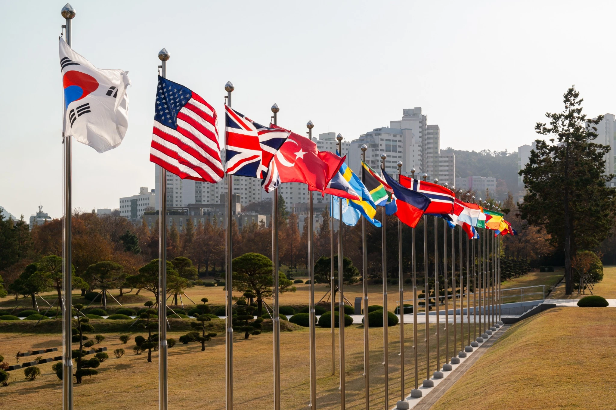 The United Nations Memorial Cemetery, located in Busan, South Korea, is fluttering in a row with flags from countries that participated in the 1950 Korean War..