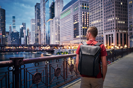 Man with a backpack walking over bridge in downtown Chicago, IL