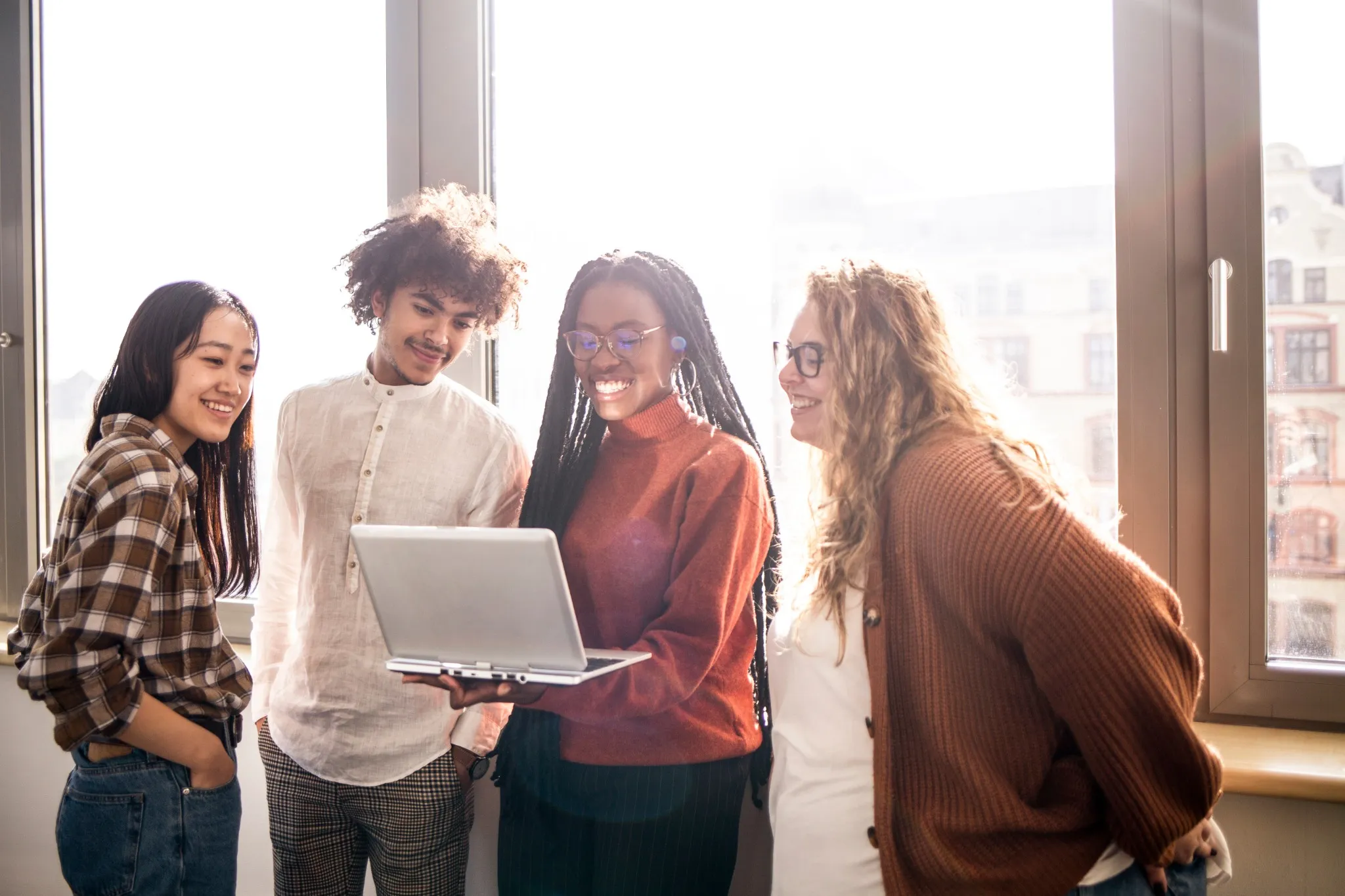Group of young folks looking at laptop