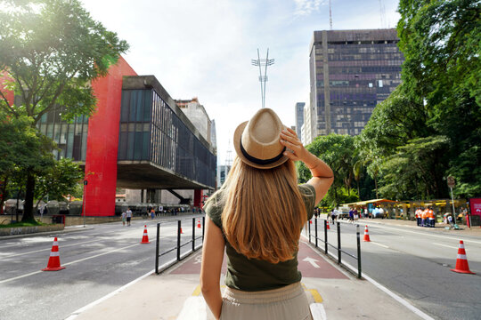 Lady walking down Paulista avenue in the daytime