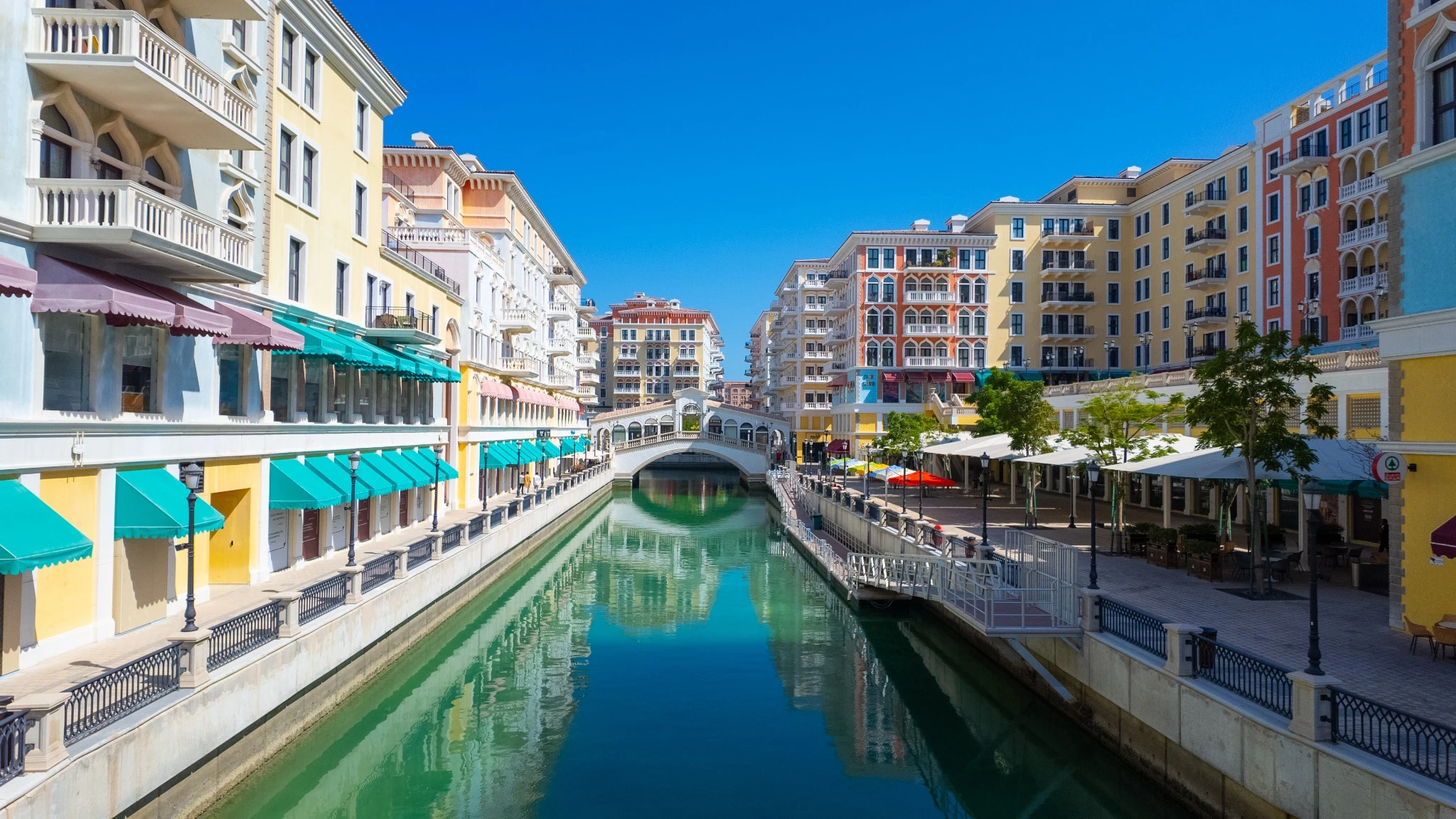 Colorful waterfront shops, cafes and residential apartments along the canals in the Venetian inspired Qanat Quartier, on the manmade artificial Pearl Island, Qatar..