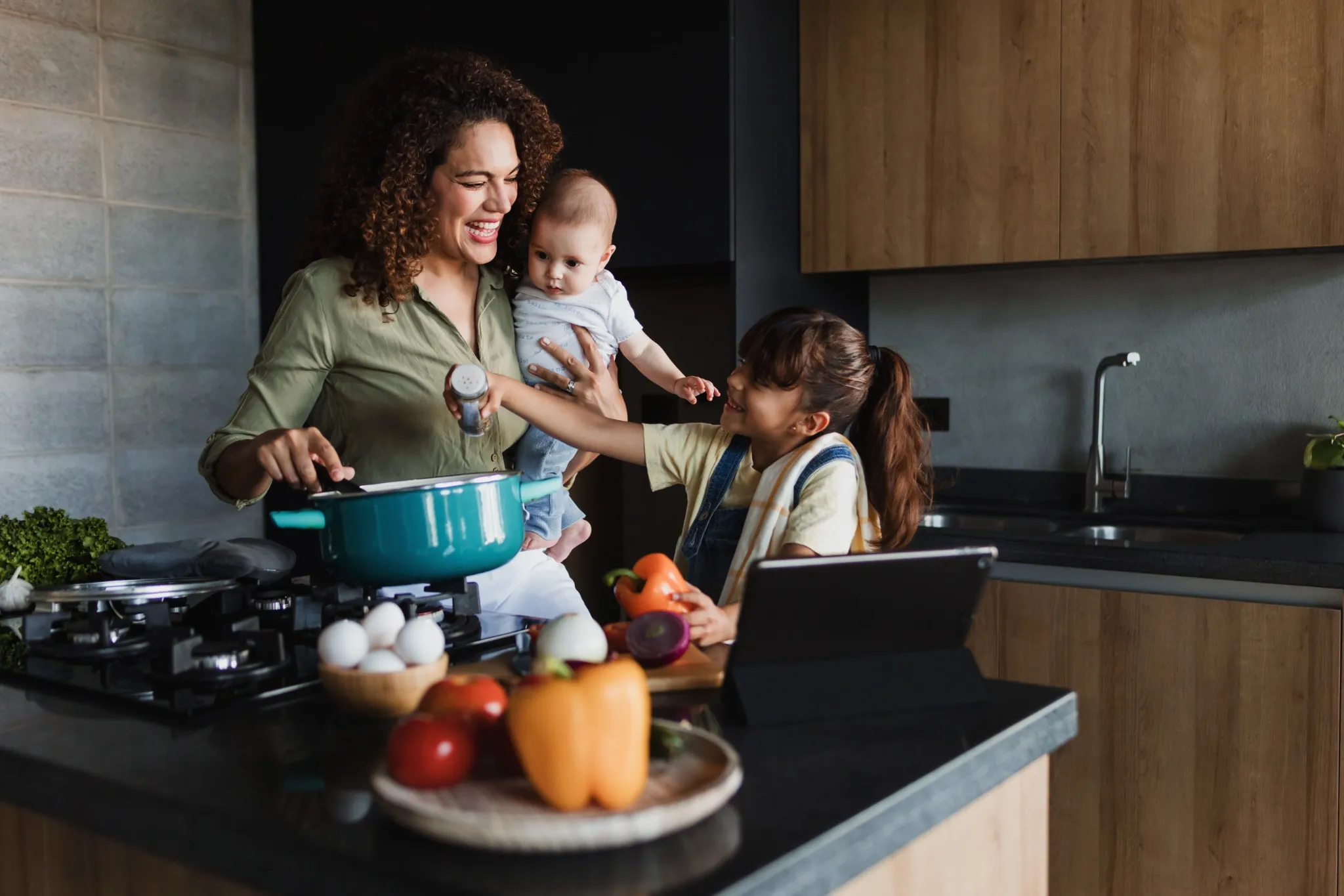hispanic mother with children son and daughter cooking at kitchen in mexico latin america.