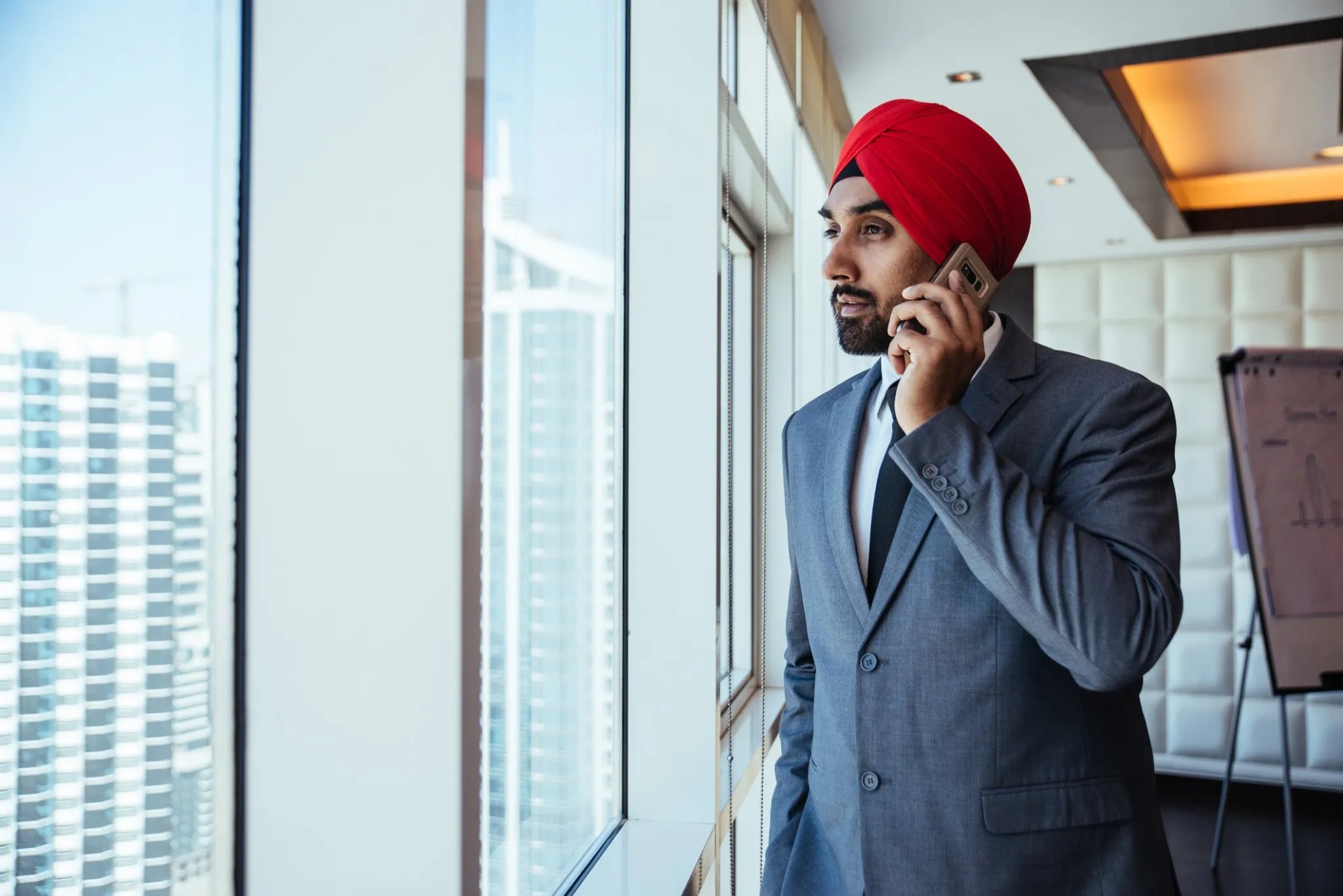 Indian businessman looking out the window in his office.