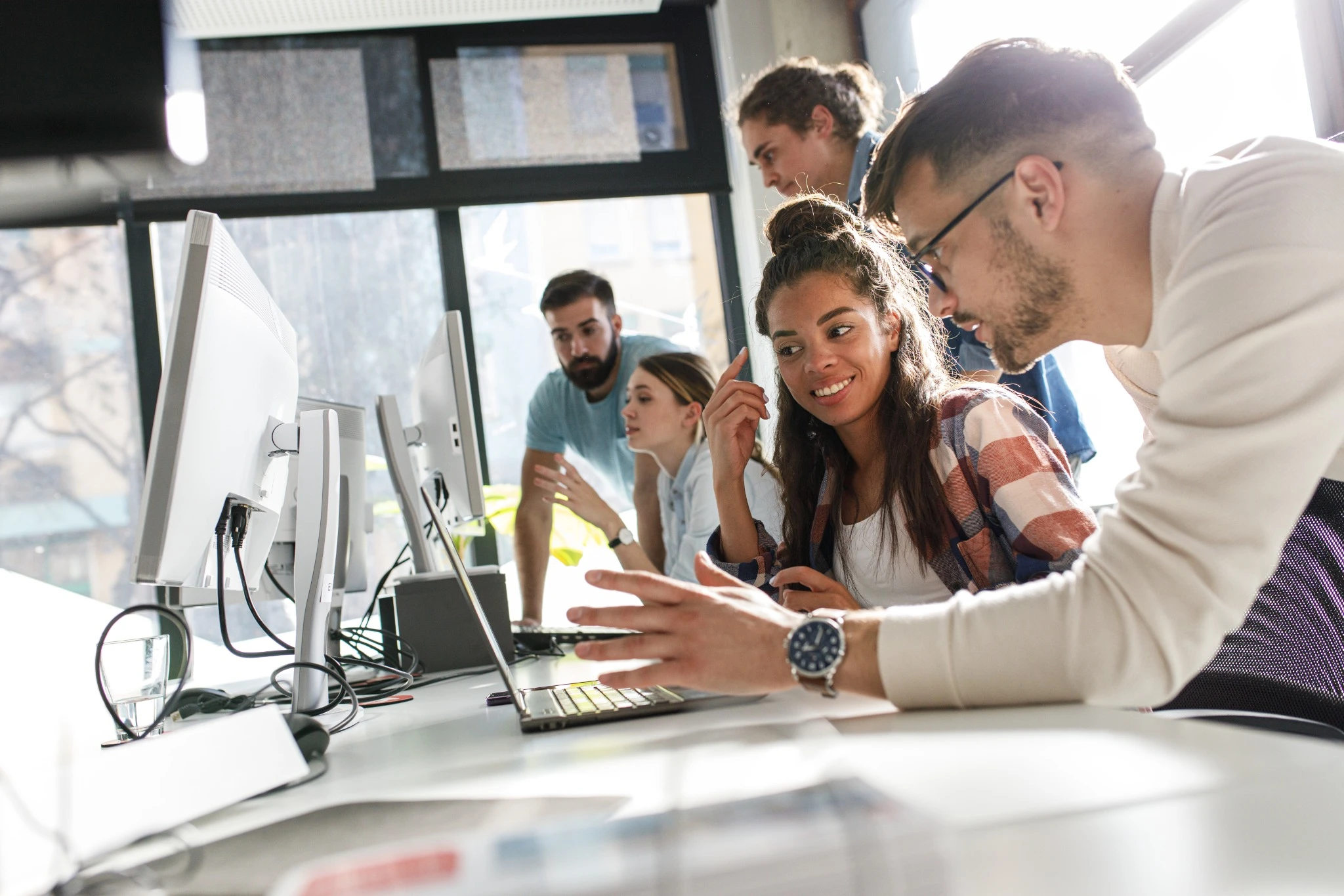 Group of team workers and programmers starting a new project.Senior programmer giving help to beginner..