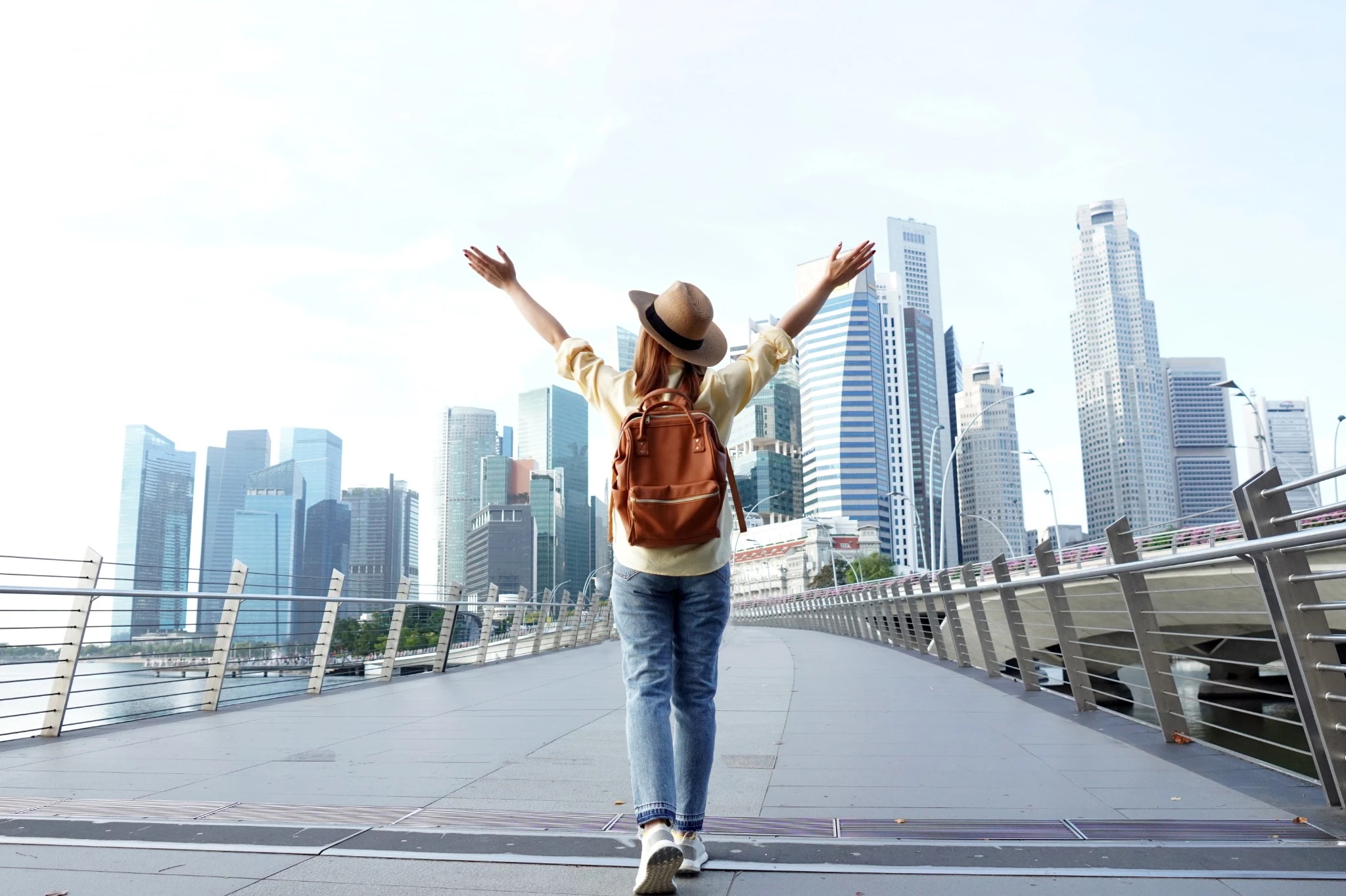 Woman with arms in the air walking down the bay walk in Singapore