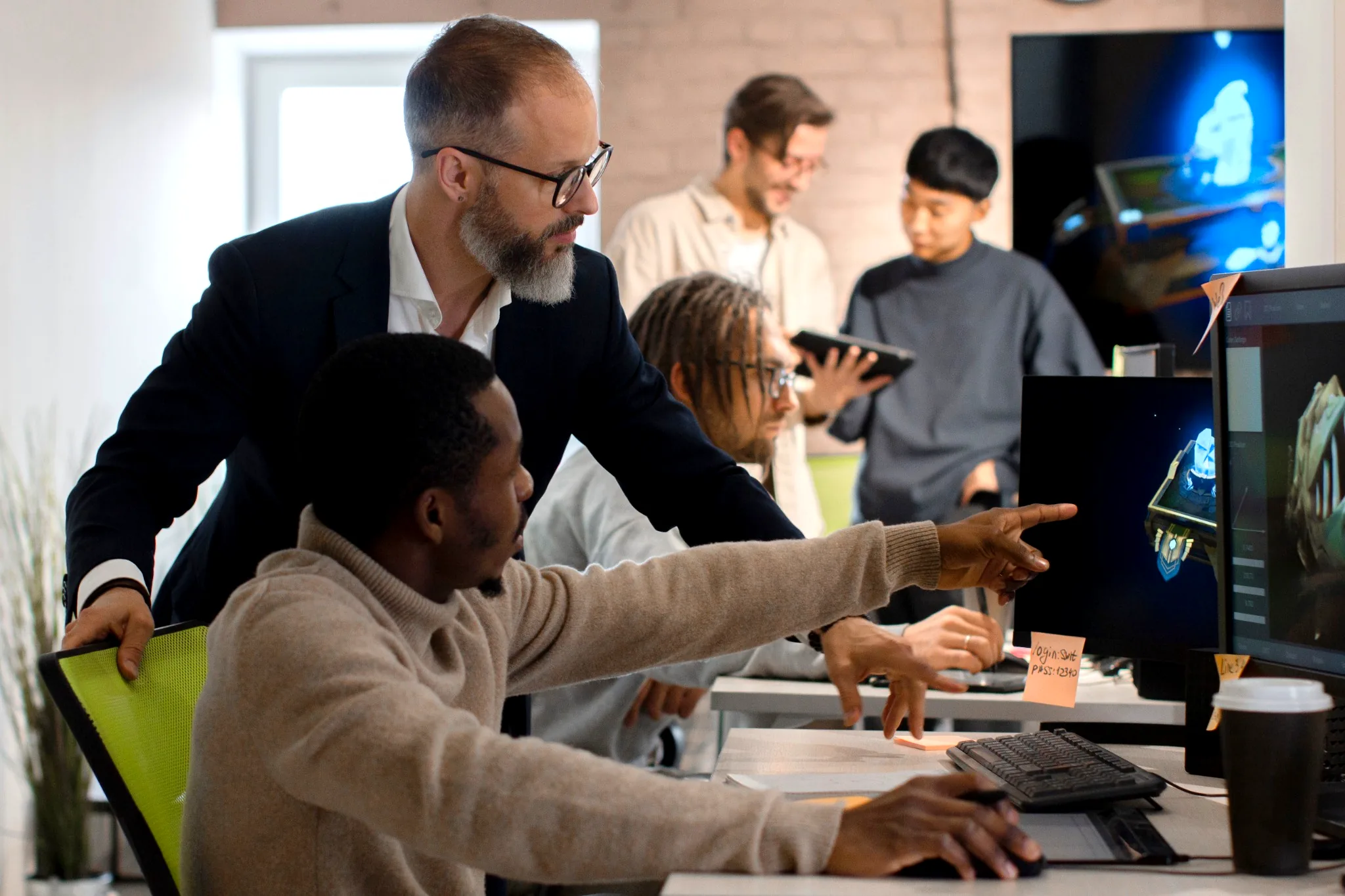 Men looking at monitors developing video games