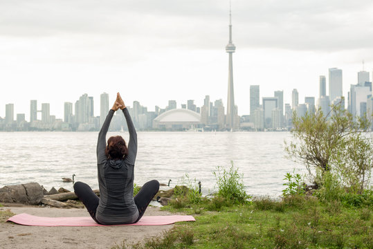 Woman Practicing Yoga in front of the Toronto Skyline