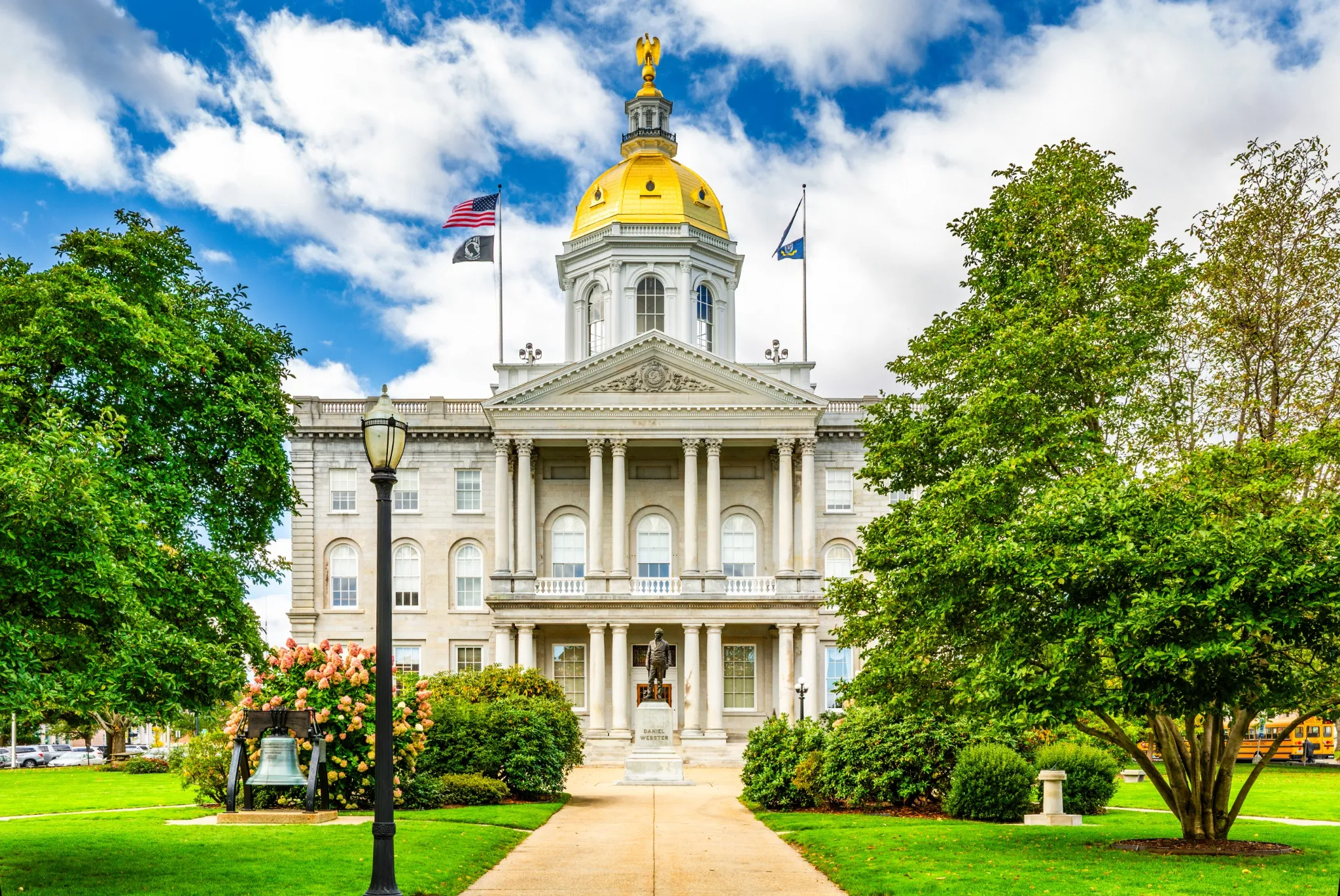 New Hampshire State House with the statue of Daniel Webster a prominent NH statesman, in Concord. The capitol houses the New Hampshire General Court, Governor, and Executive Council..