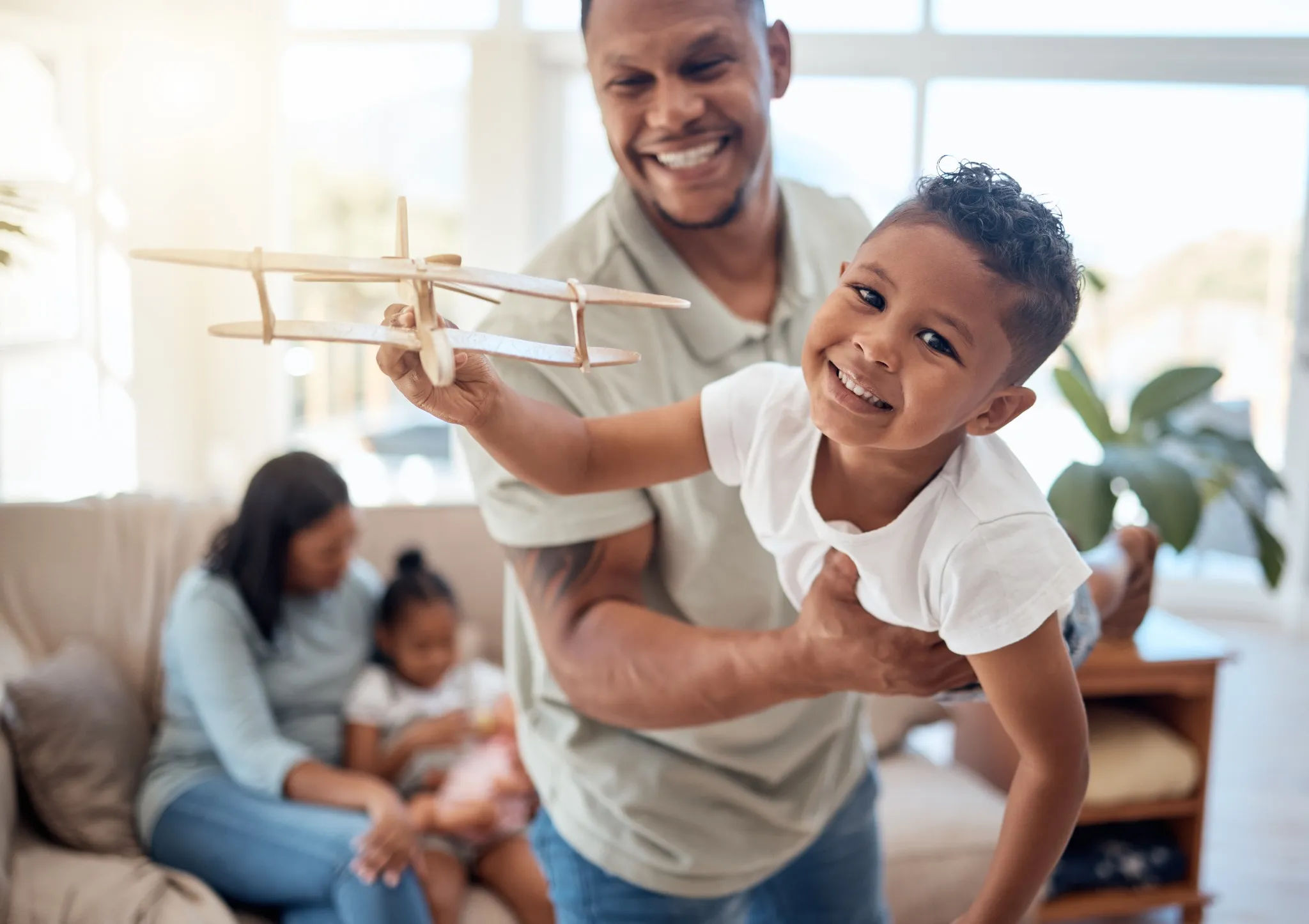 Dad, boy and toy plane in living room for game, fun or bonding while happy together.