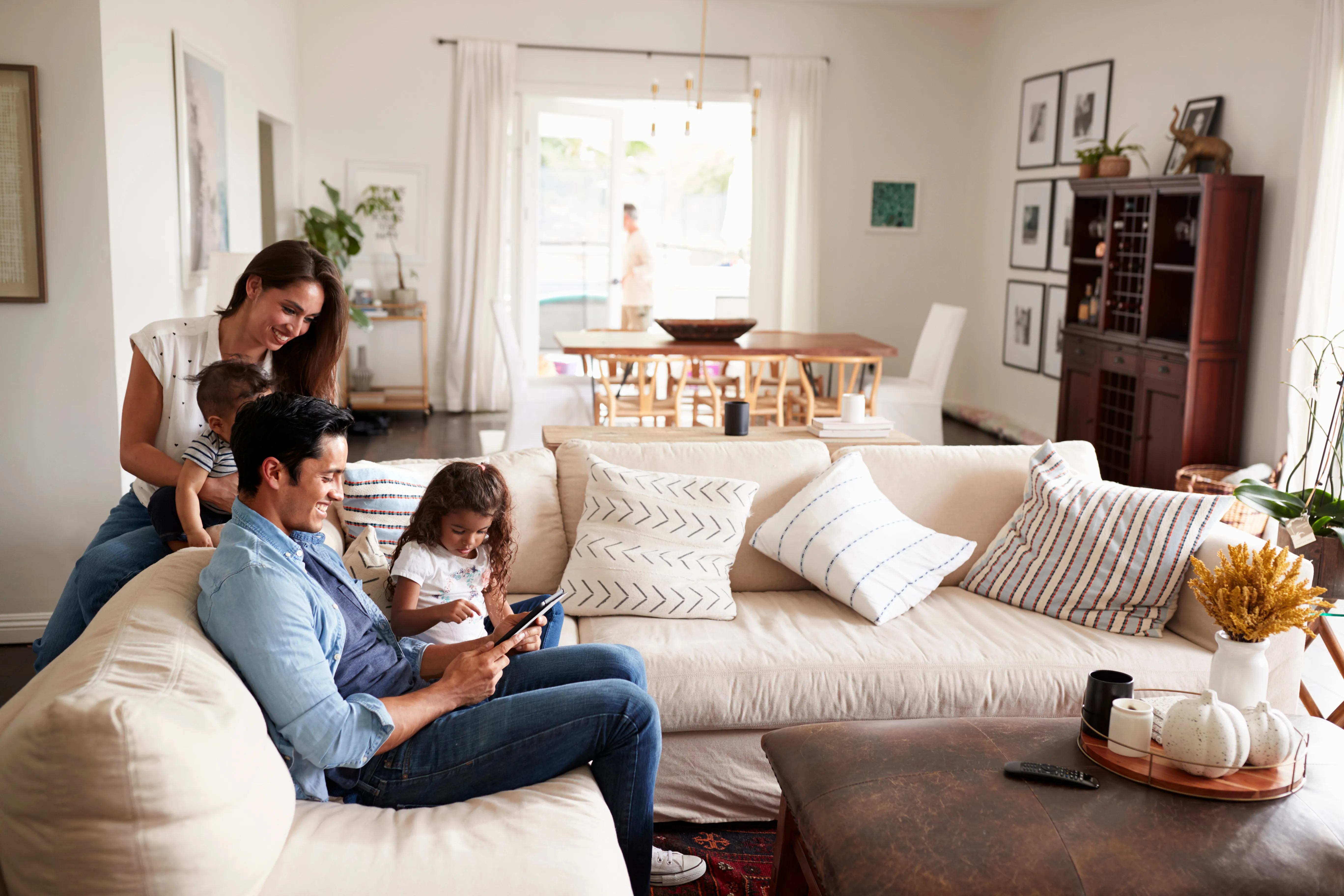 Family with two young children sitting on couch smiling