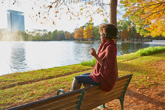Woman listening to music at the park in the sun