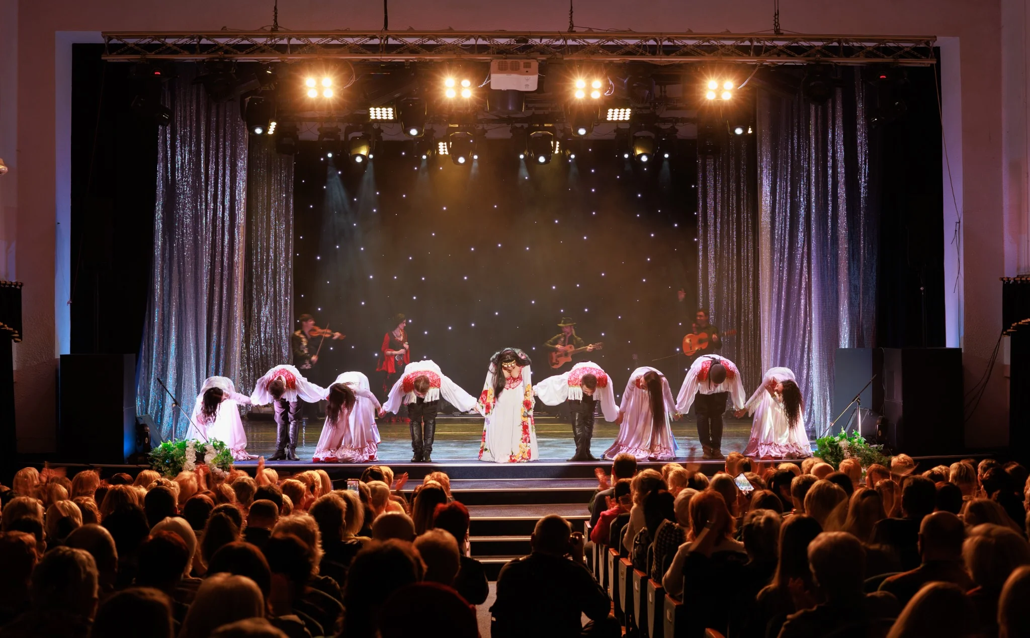 Actors and actresses bowing on stage after theatrical performance