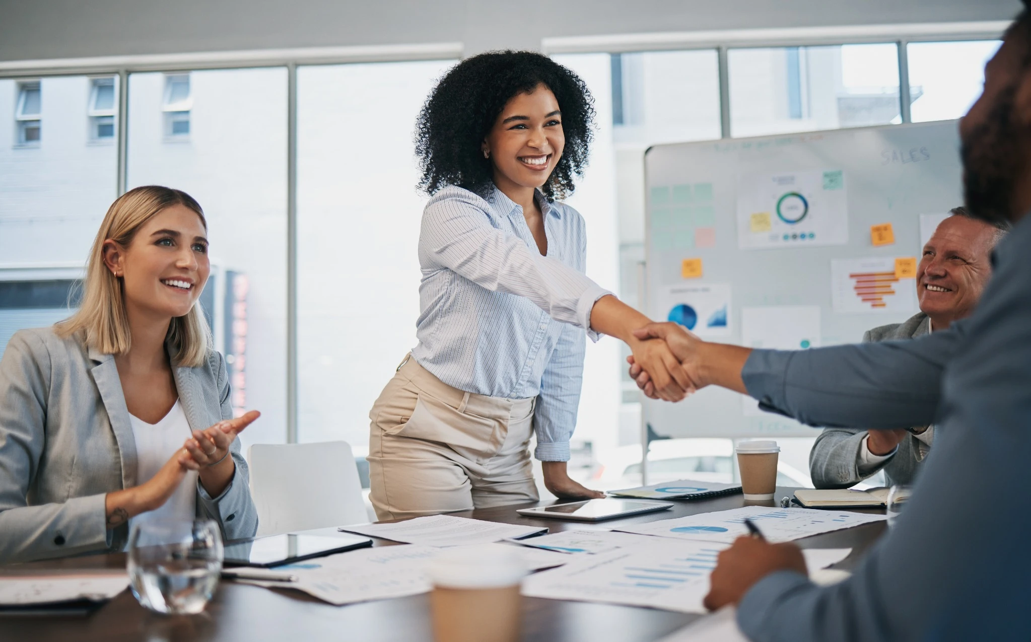 Woman smiling and shaking hands after a presentation