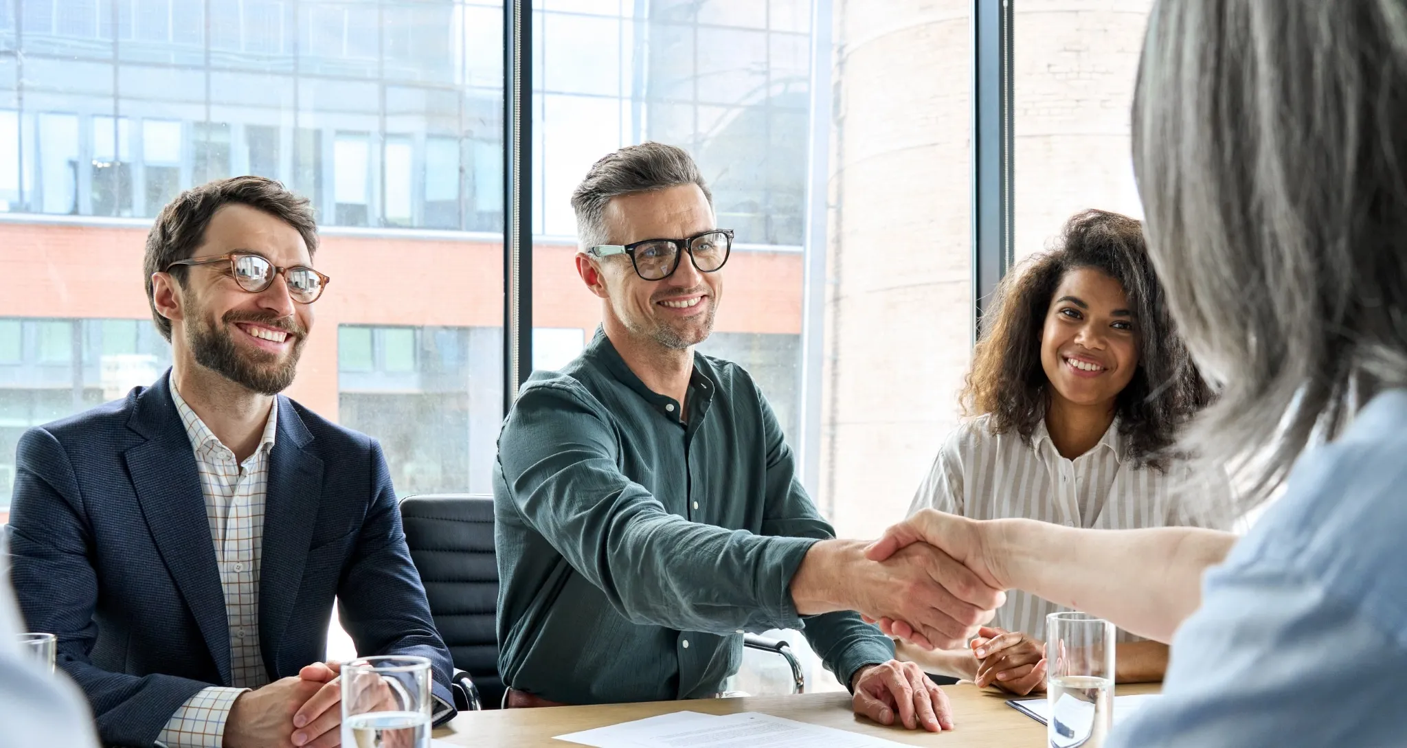 Business partnerts shaking hands across the table