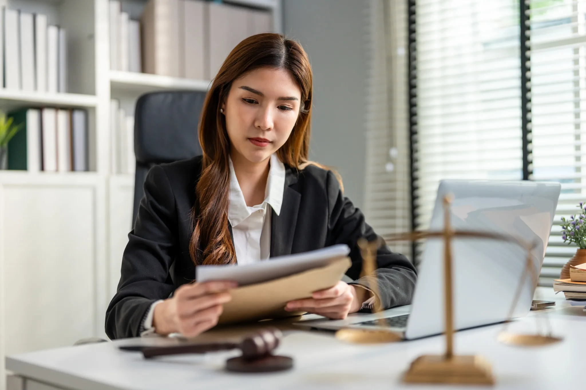 Woman who is a government employee at office desk reviewing paperwork