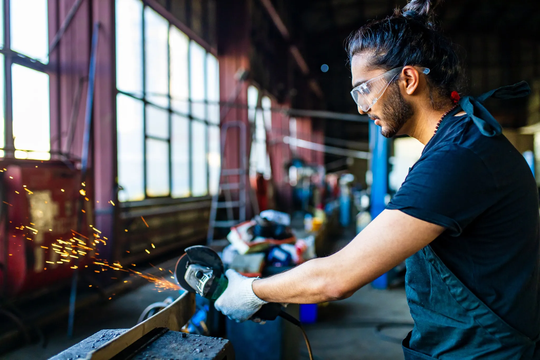 eastern ethnic handsome black hair and beard man in uniform is working in auto service.