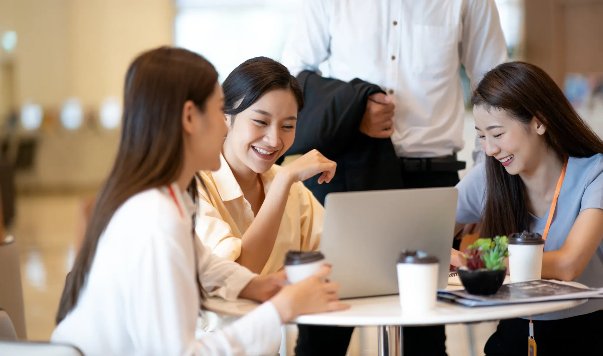 Happy young Asian business people discussing creative project 